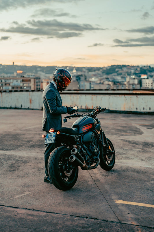 Motociclista en la ciudad durante su trayecto al trabajo, desplazándose entre los coches con facilidad y con el equipamiento adecuado.