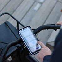 Vista del smartphone fijado en el manillar de la bicicleta en su funda magnética perfectamente táctil. Ideal para la navegación por la ciudad