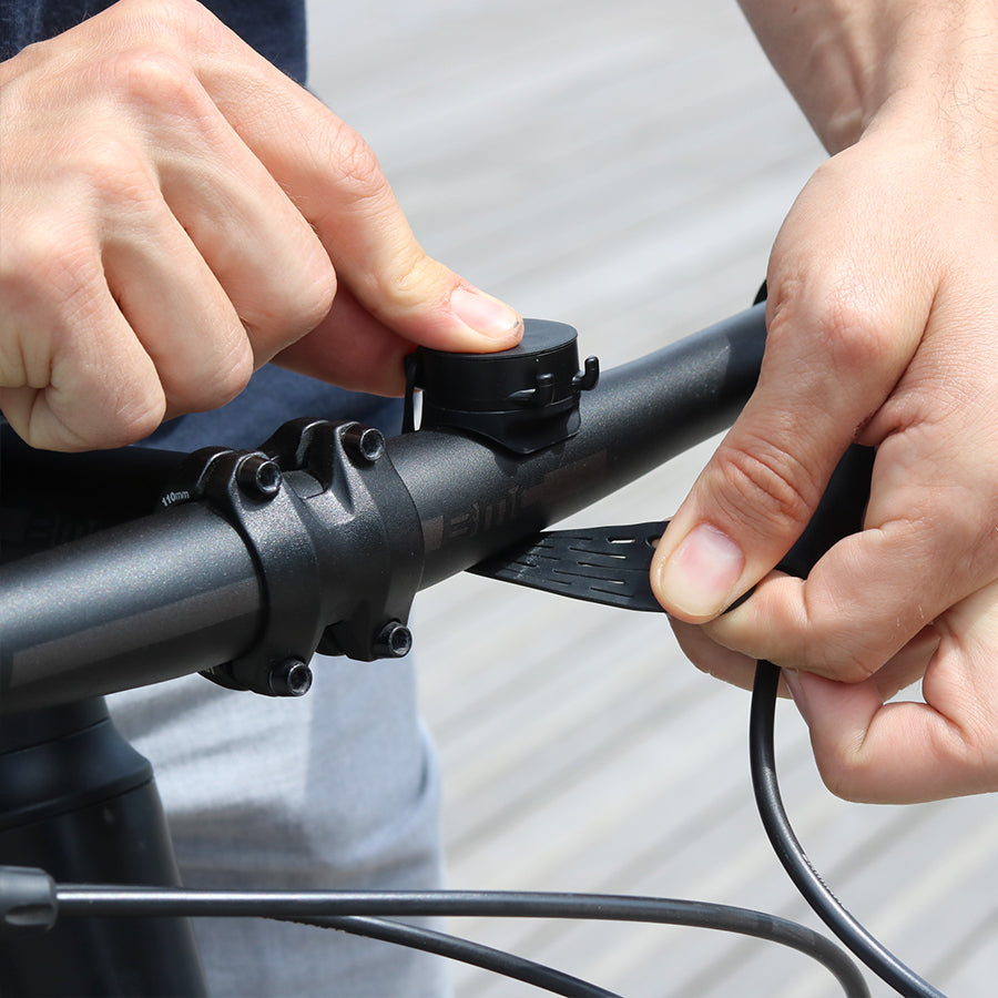 Fijación con correa elástica del soporte de teléfono Shapeheart en el manillar de bicicleta.
