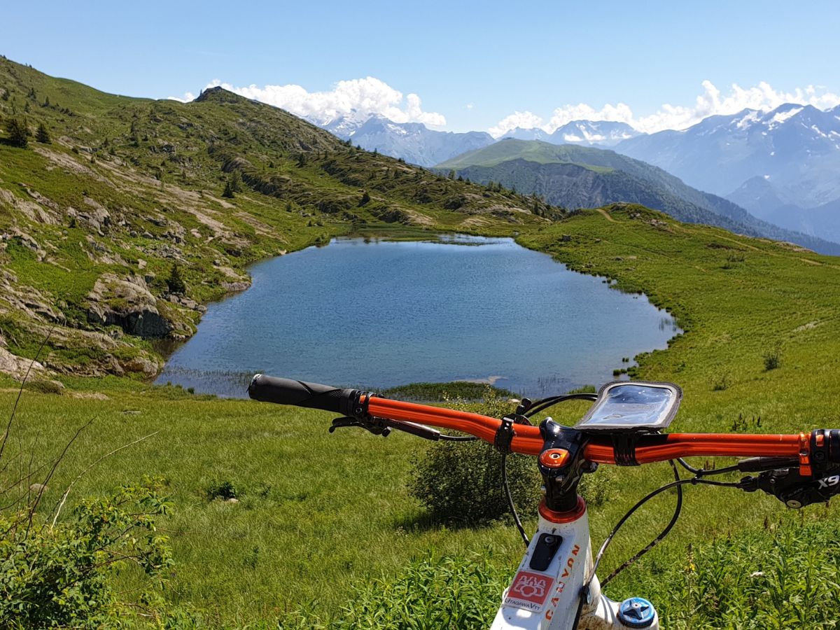 Vista de un ciclista conectando una batería externa a su smartphone montado en la bicicleta.