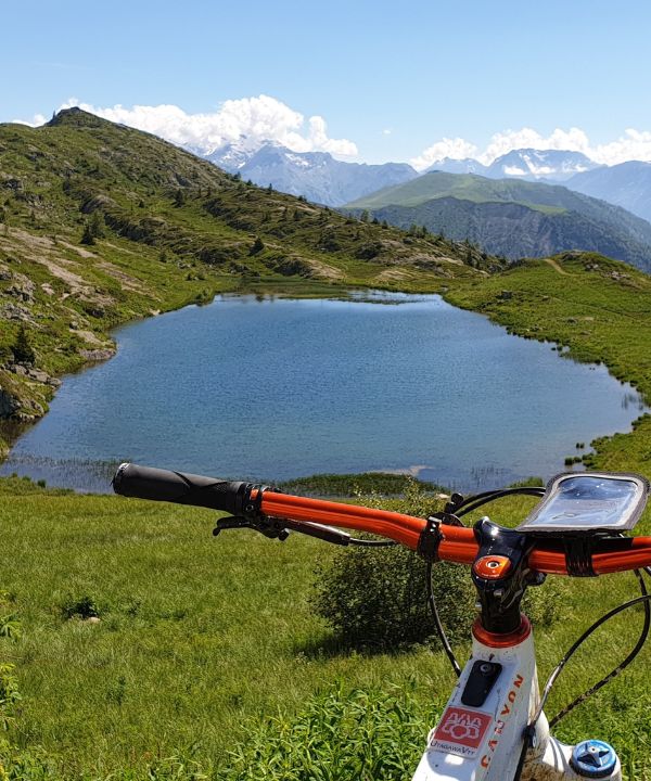 Vista de un ciclista conectando una batería externa a su smartphone montado en la bicicleta.