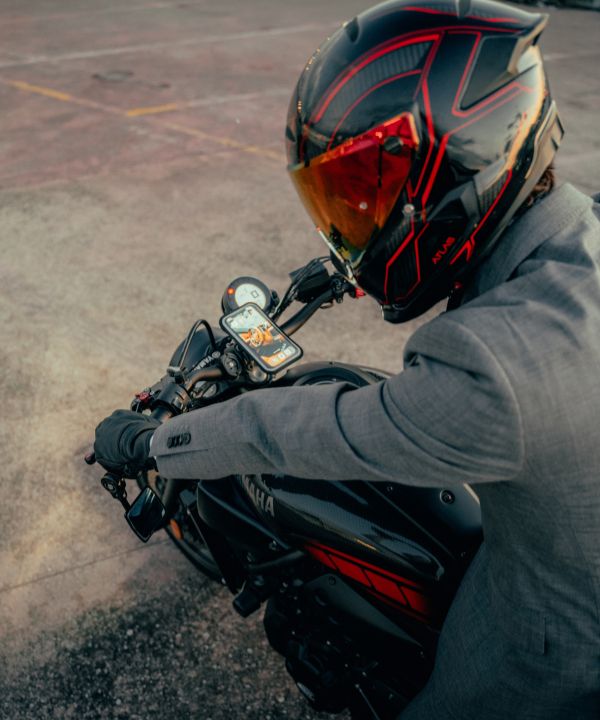 Contenido minimalista de una bolsa de motociclista: guantes, candado compacto, powerbank.
