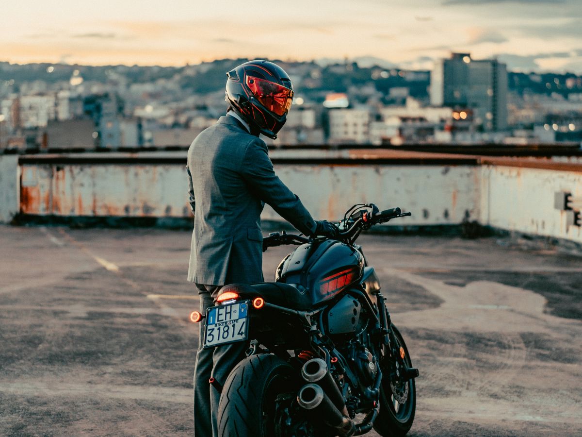 Motorista bajando de su moto y guardando sus cosas rápidamente al llegar.