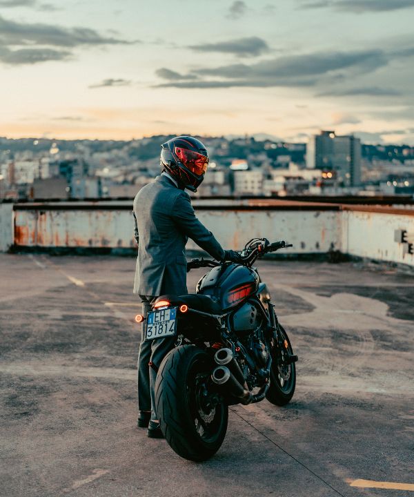 Motorista bajando de su moto y guardando sus cosas rápidamente al llegar.