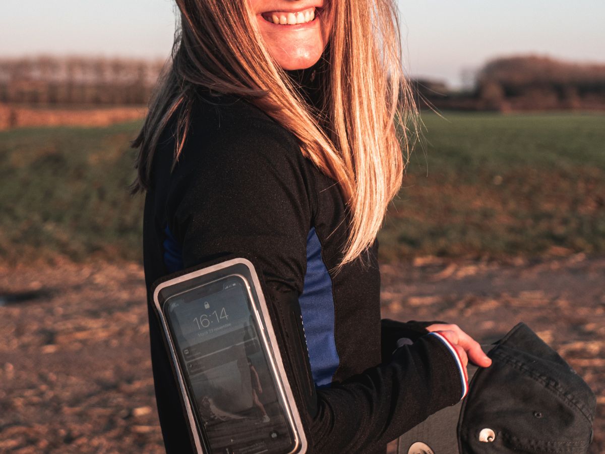 Runner escuchando música con auriculares inalámbricos durante un entrenamiento.