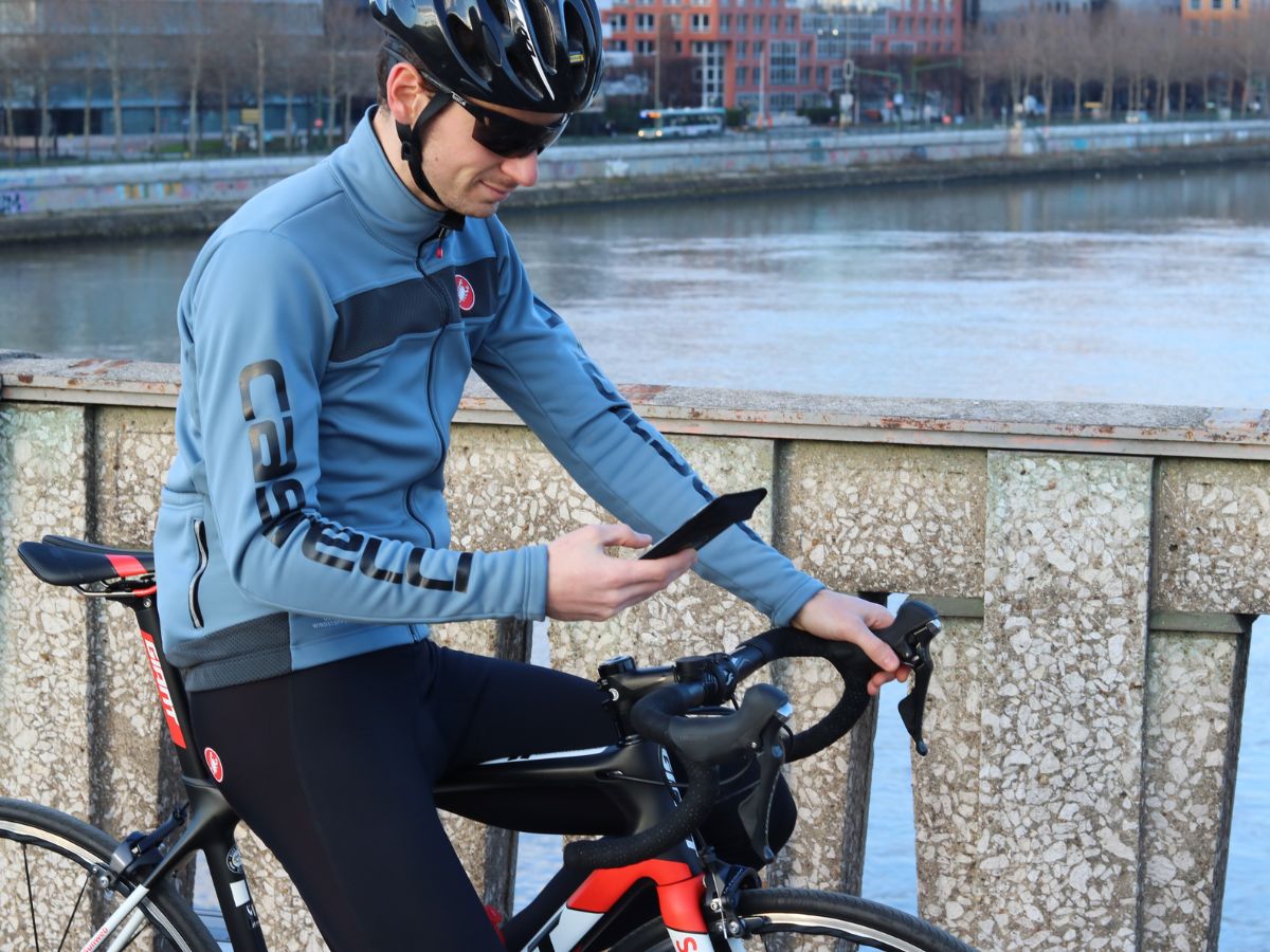 Ciclista con teléfono fijado al manillar mediante soporte Shapeheart.