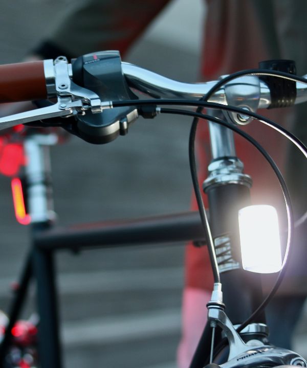 Luz delantera blanca Shapeheart fijada en una bicicleta, proporcionando una iluminación potente para conducir de noche con total tranquilidad.