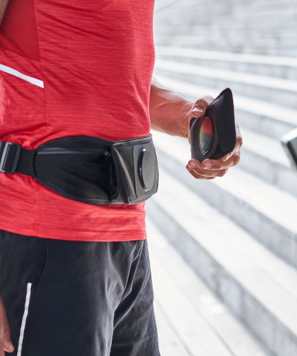 Corredor ajustando el cinturón de running Shapeheart para un soporte estable y cómodo antes de su entrenamiento.