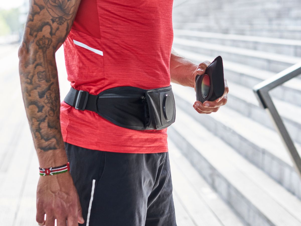 Corredor ajustando el cinturón de running Shapeheart para un soporte estable y cómodo antes de su entrenamiento.