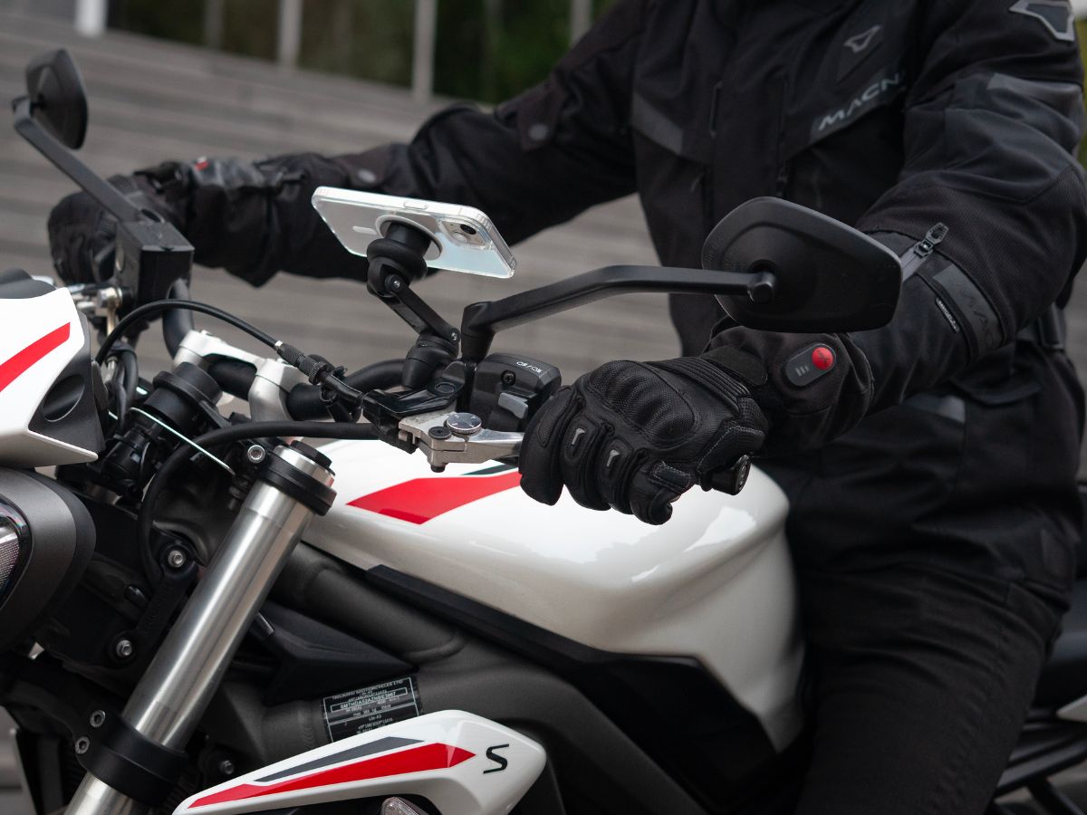 Un semáforo en rojo con un motociclista listo para arrancar, ilustrando la necesidad de dominar las salidas. La postura del motociclista muestra su concentración antes de retomar la carretera.