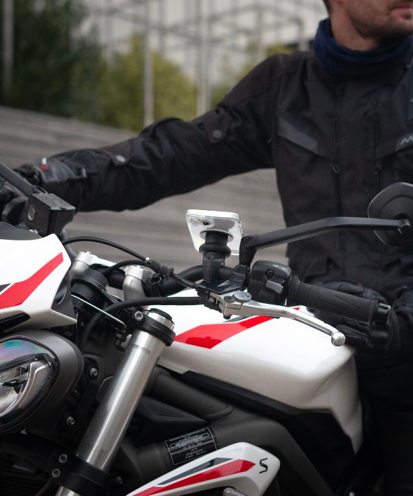 Un motorista con una chaqueta reflectante con su luz encendida, ilustrando la importancia de ser visible. La imagen insiste en el equipamiento de seguridad para reducir el riesgo de accidentes.