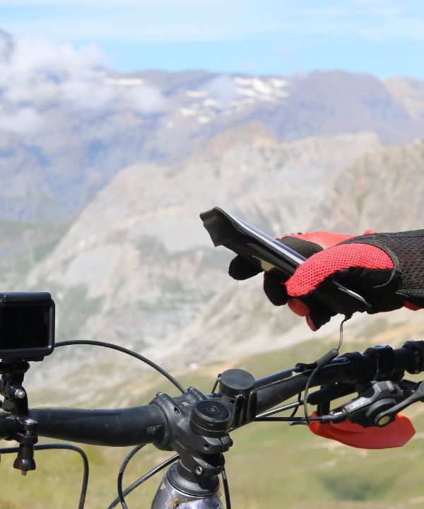 Soporte de bicicleta Shapeheart fijado en el manillar de una bicicleta de montaña, destacando su compatibilidad universal y su estabilidad en terrenos extremos.