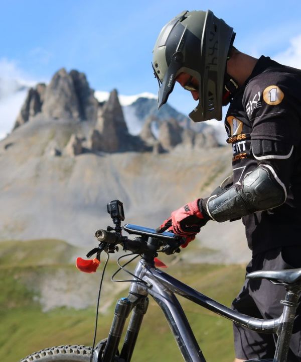 Teléfono fijado en un manillar Shapeheart con GPS visible, destacando la utilidad de un smartphone accesible en MTB de descenso.