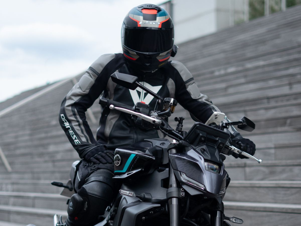 Moto con dos personas en curva, mostrando la adaptación de la conducción con un pasajero en la parte trasera.