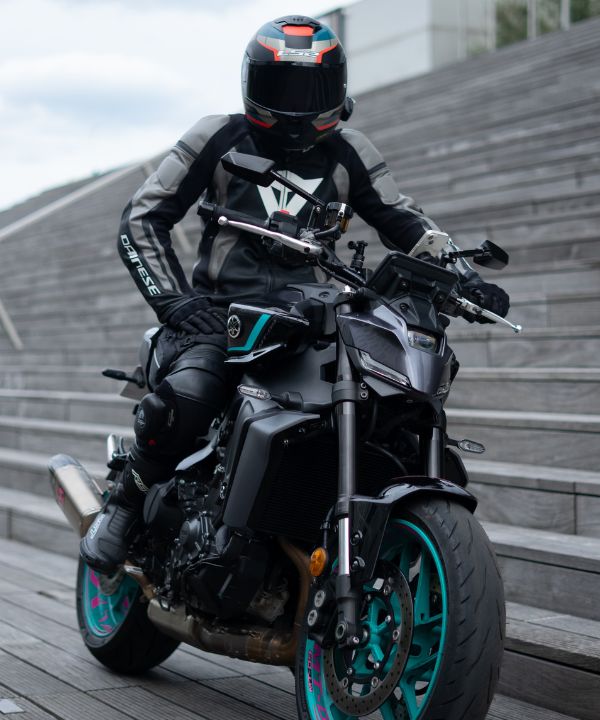 Moto con dos personas en curva, mostrando la adaptación de la conducción con un pasajero en la parte trasera.