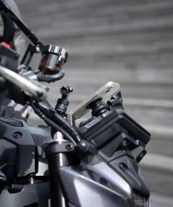 Teléfono fijado en un soporte Shapeheart en moto con pasajero, GPS visible, seguridad y accesibilidad máximas.