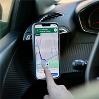 Conductor utilizando una aplicación GPS en un smartphone fijado con el soporte Shapeheart para coche