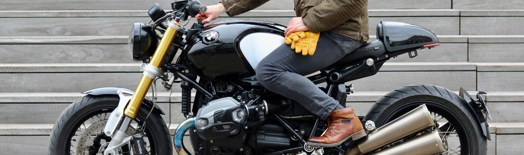 Joven motociclista con equipo, feliz de empezar en su primera moto, listo para equiparse y rodar con seguridad.