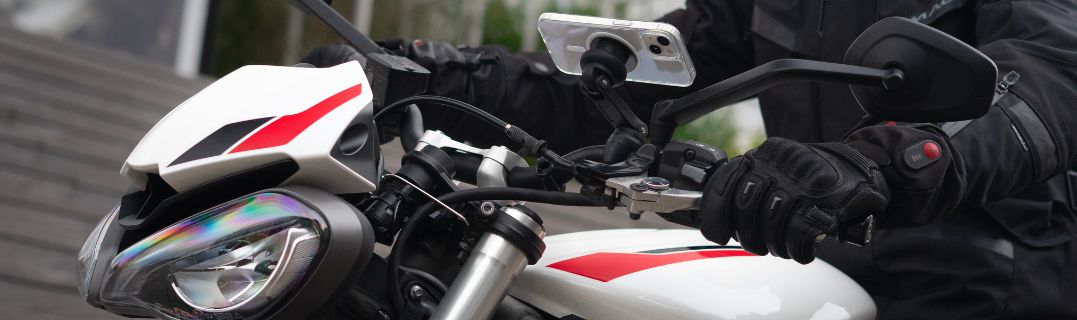 Un motociclista circulando por la ciudad entre los coches, ilustrando los desafíos del tráfico urbano. La imagen muestra la importancia de anticipar bien los movimientos de los demás usuario