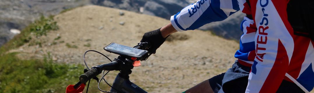 Un ciclista de montaña en plena bajada por un sendero técnico, ilustrando la importancia de un equipamiento fiable en MTB downhill.