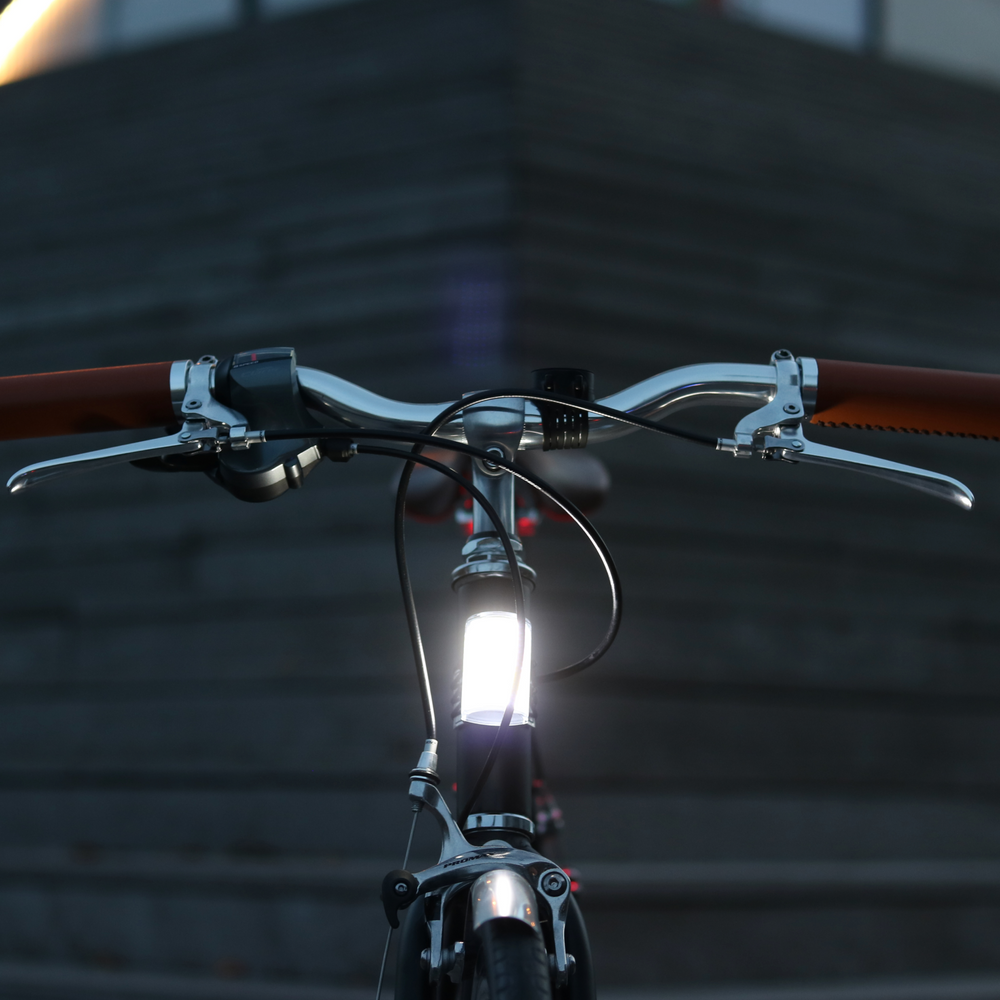 Luz delantera Shapeheart instalada en una bicicleta, visibilidad reforzada gracias a un potente haz LED panorámico y soporte de teléfono magnético